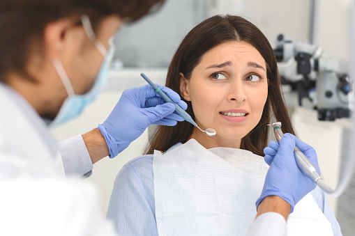 wystraszona kobieta w gabinecie dentystycznym