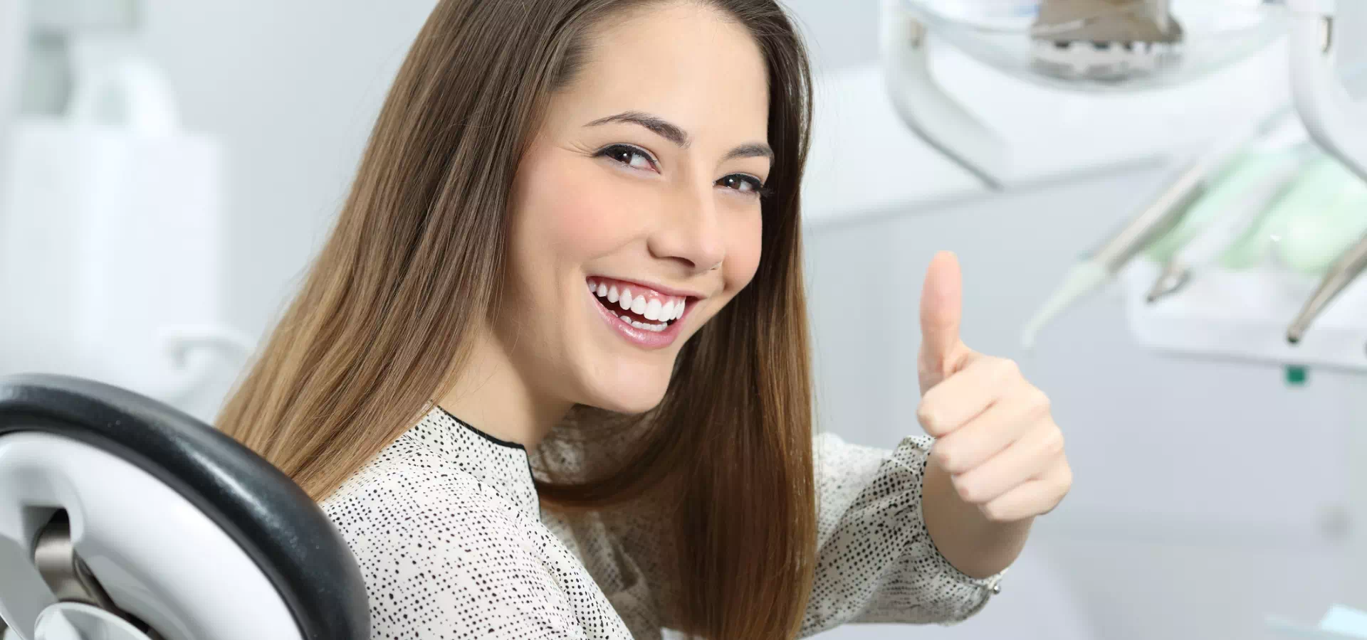 uśmiechnięta kobieta na fotelu dentystycznym